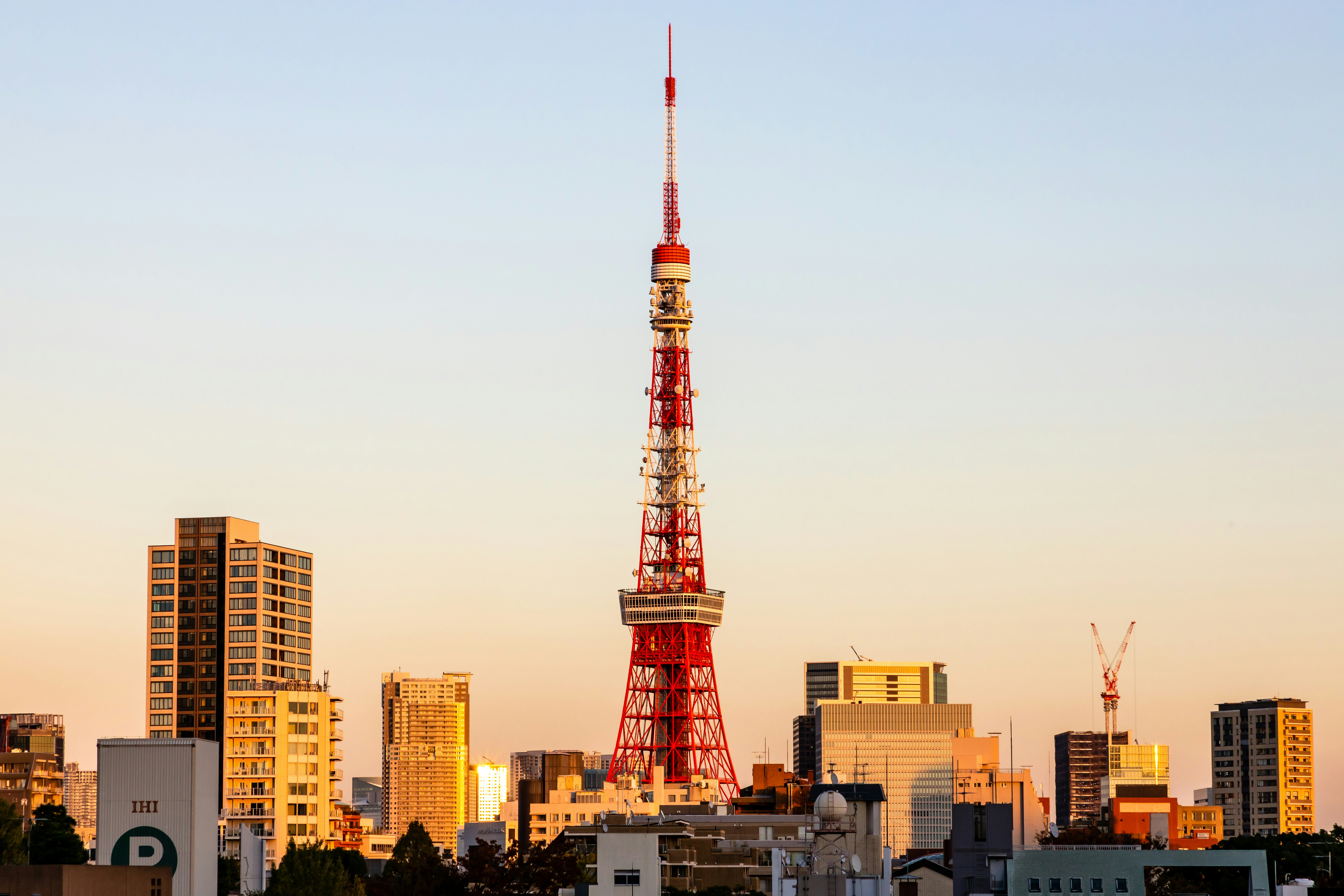 Red and white tower near city buildings during daytime