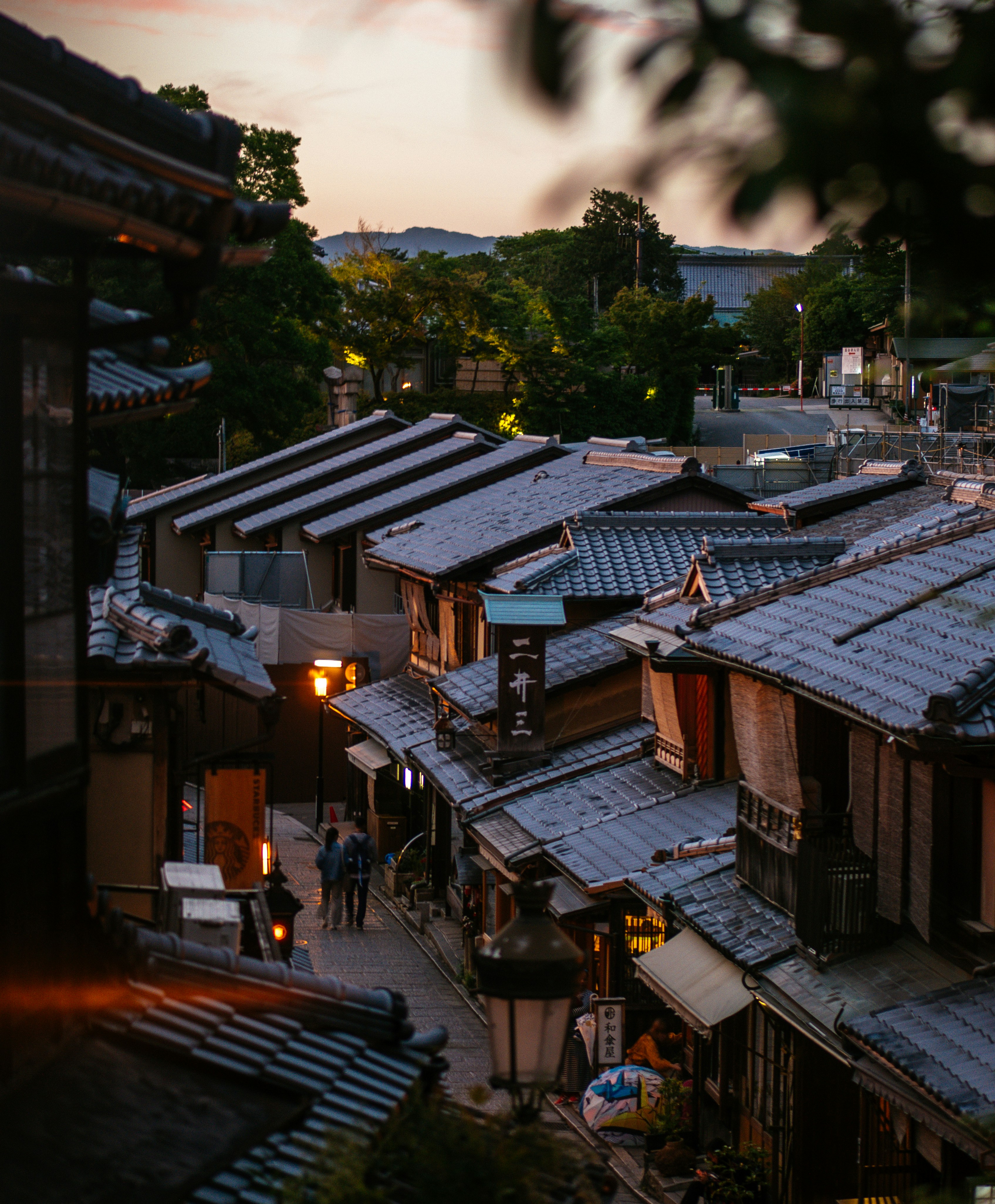 Brown wooden houses near green trees during daytime