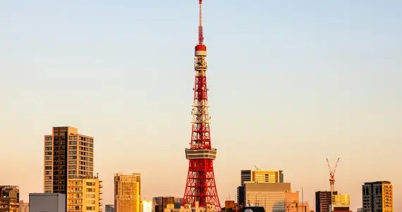 Red and white tower near city buildings during daytime